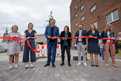 Das rote Band ist durchtrennt - und die neu gestalteten öffentliche Räume sind nun für alle zugänglich. V.l.n.r.: Heike Marzen (Geschäftsführerin Wirtschaftsförderung), Susanne Linnebach (Leiterin Amt für Stadterneuerung), OB Westphal, Hannah Rosenbaum (Bezirksbürgermeisterin Innenstadt Nord), Heiko Just (Leitung Grünflächenamt), Sylvia Uehlendahl (Leiterin Tiefbauamt), Uta Wittig-Flick (Amt für Stadterneuerung).